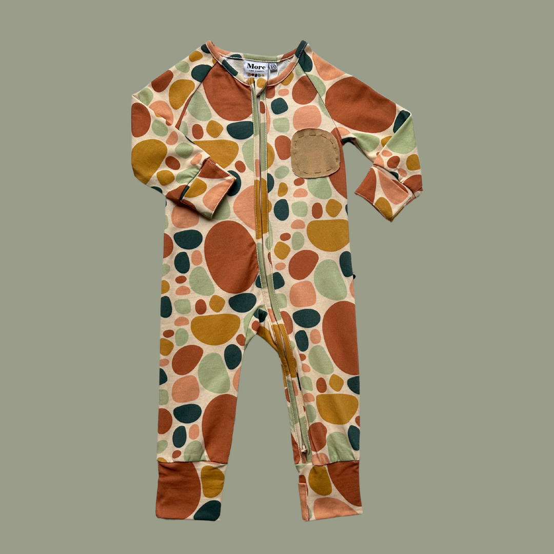 More The Label organic cotton stone print baby romper flatlay image of front. Features stoneprint fabric and handstitched stone at wearers left had chest.