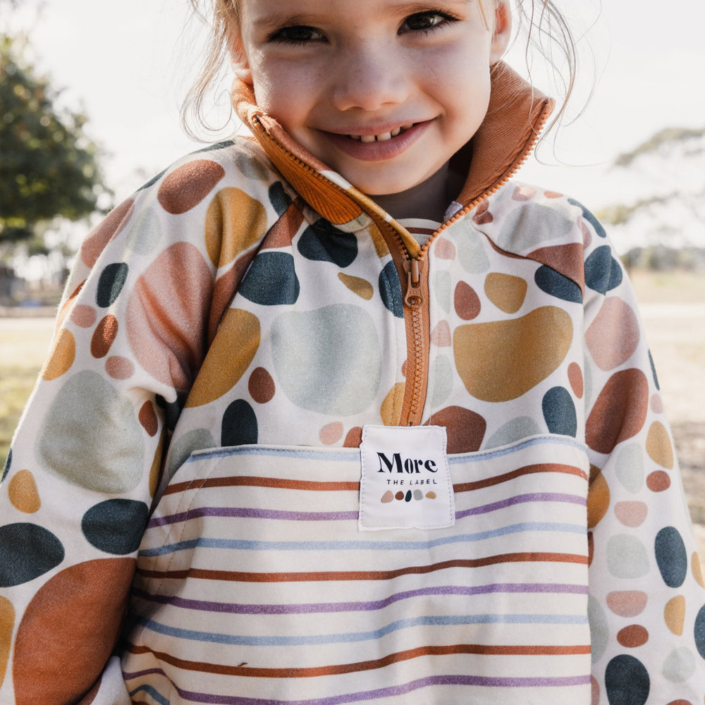 Close up photo of three year old child smiling wearing More the label stone print pullover.