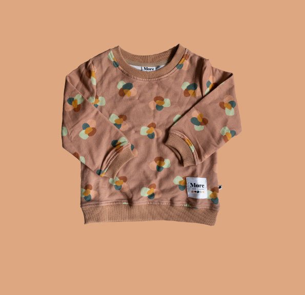 Flat lay image of More the label stone huddle jumper on peach background.