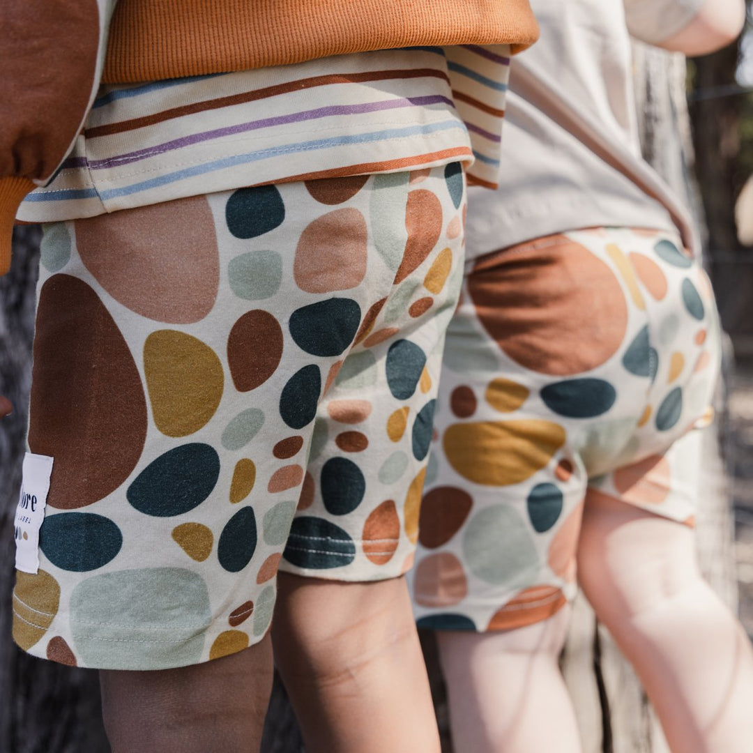 Close up image of two children wearing More the label stone print bike shorts.